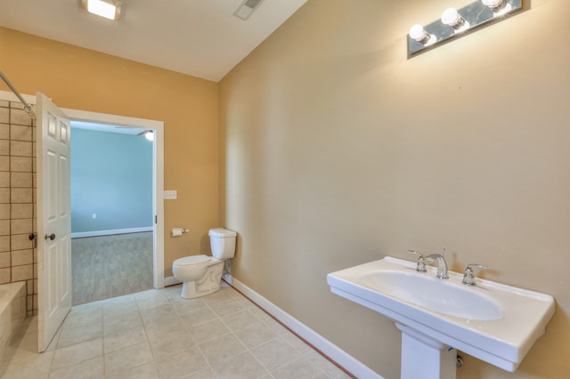 full bathroom with tile patterned flooring, bathing tub / shower combination, toilet, and sink