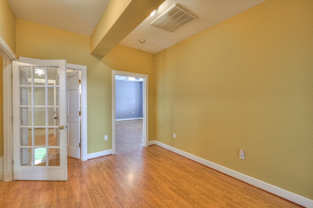 empty room with lofted ceiling and light wood-type flooring