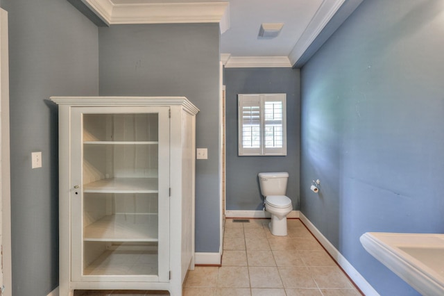 bathroom with tile patterned floors, toilet, and ornamental molding