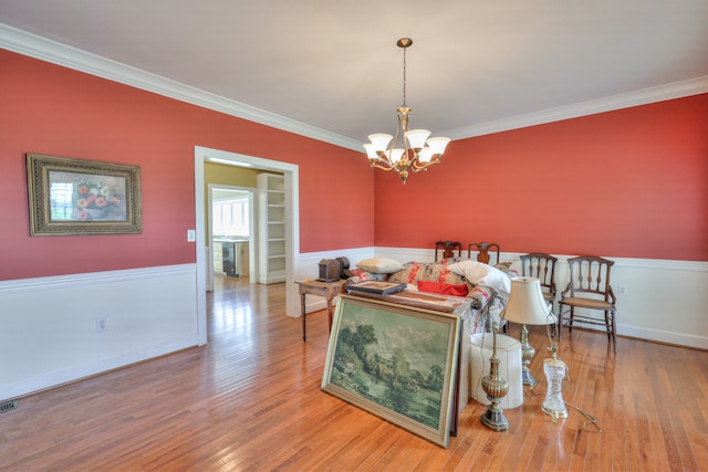 living room featuring a notable chandelier, hardwood / wood-style floors, and ornamental molding