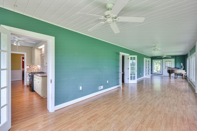 unfurnished living room with ceiling fan, light hardwood / wood-style flooring, and french doors
