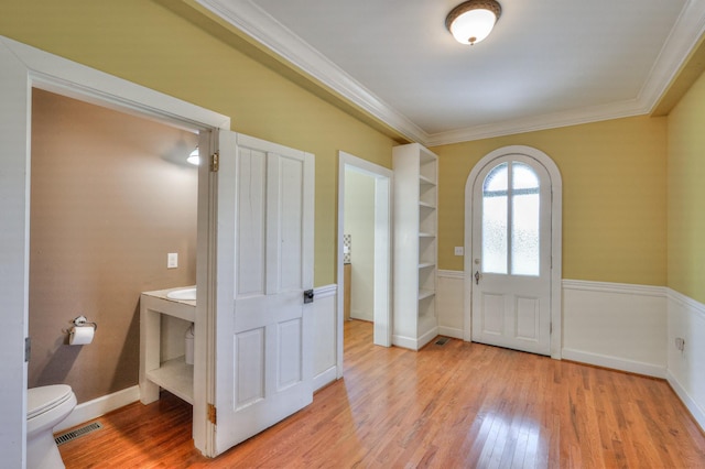 foyer featuring ornamental molding and light hardwood / wood-style floors