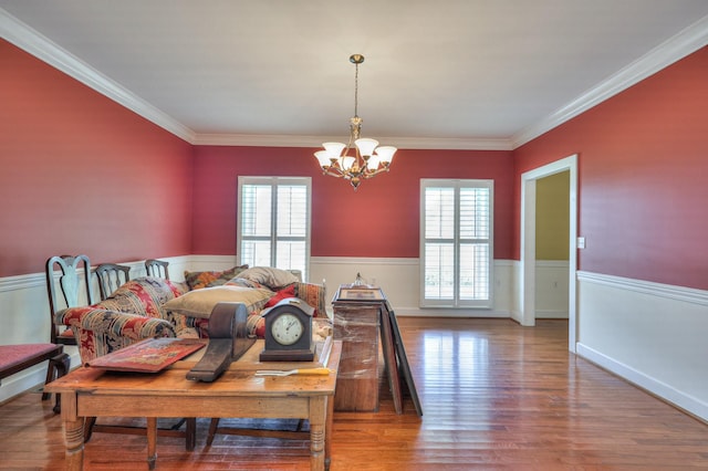dining space with a notable chandelier, ornamental molding, a wealth of natural light, and hardwood / wood-style floors