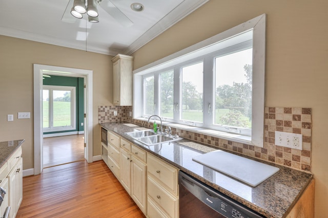 kitchen with dark stone counters, sink, tasteful backsplash, and light hardwood / wood-style flooring