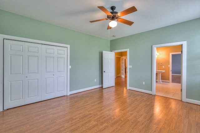 unfurnished bedroom with sink, light wood-type flooring, a closet, ceiling fan, and ensuite bathroom