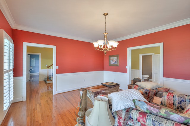 bedroom with crown molding, light hardwood / wood-style floors, and a chandelier