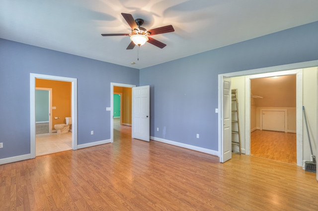 unfurnished bedroom featuring ceiling fan, light wood-type flooring, and ensuite bath