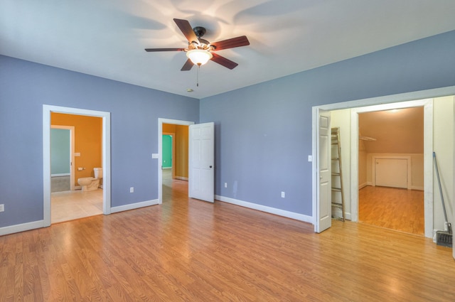 unfurnished bedroom with ensuite bathroom and light hardwood / wood-style floors