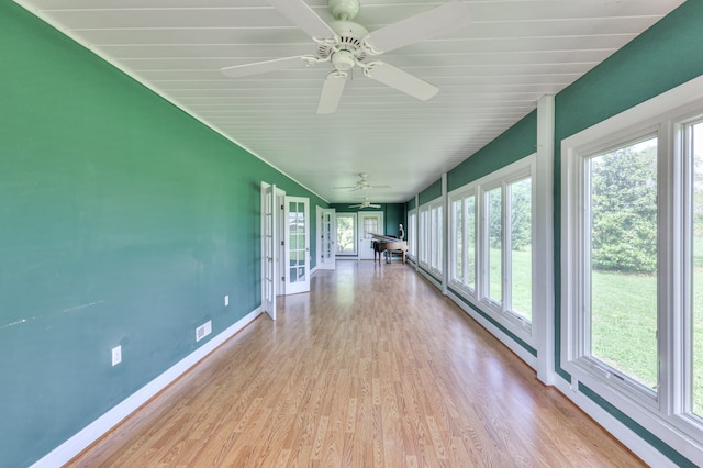 unfurnished sunroom with ceiling fan and a wealth of natural light