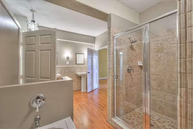 bathroom featuring tile walls, a shower with shower door, and wood-type flooring