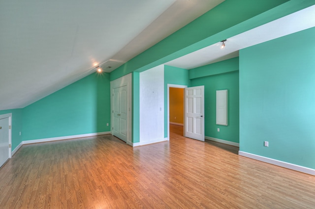 additional living space featuring vaulted ceiling and wood-type flooring