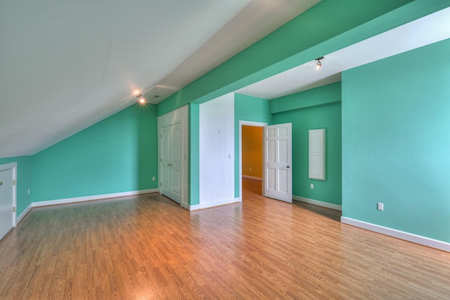 additional living space featuring light hardwood / wood-style flooring and lofted ceiling