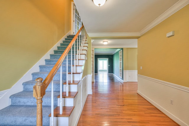 staircase with hardwood / wood-style flooring and crown molding