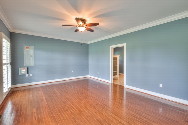 empty room featuring ceiling fan, ornamental molding, electric panel, and light hardwood / wood-style floors