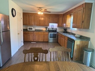 kitchen with ceiling fan, electric stove, dishwashing machine, stainless steel refrigerator, and sink