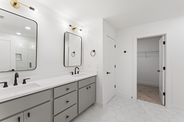 bathroom with a shower with door, vanity, and tile patterned floors