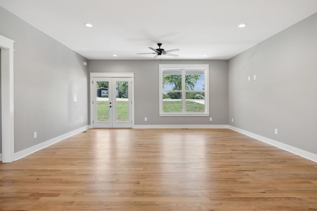 empty room featuring ceiling fan, french doors, and light hardwood / wood-style floors