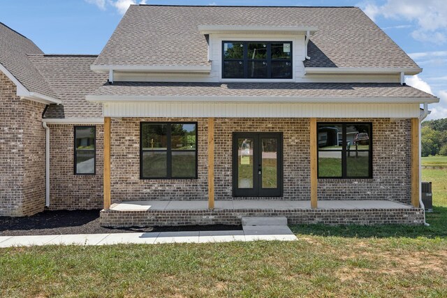 back of house featuring french doors, a yard, and a porch