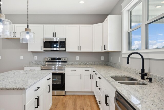 kitchen with pendant lighting, white cabinets, and stainless steel appliances