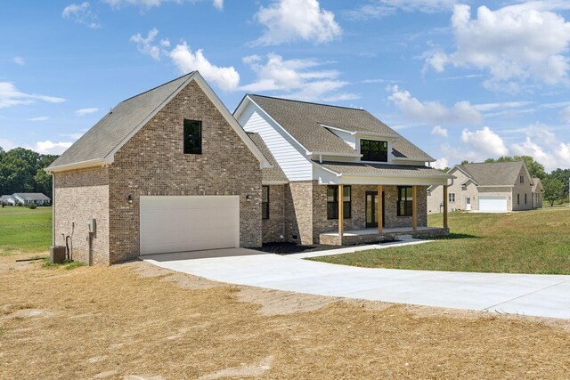 view of front of home featuring a front lawn, a porch, and a garage