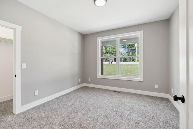 carpeted empty room featuring visible vents and baseboards