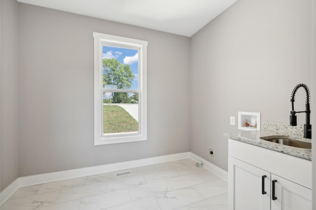 laundry area with marble finish floor, a sink, electric dryer hookup, and baseboards