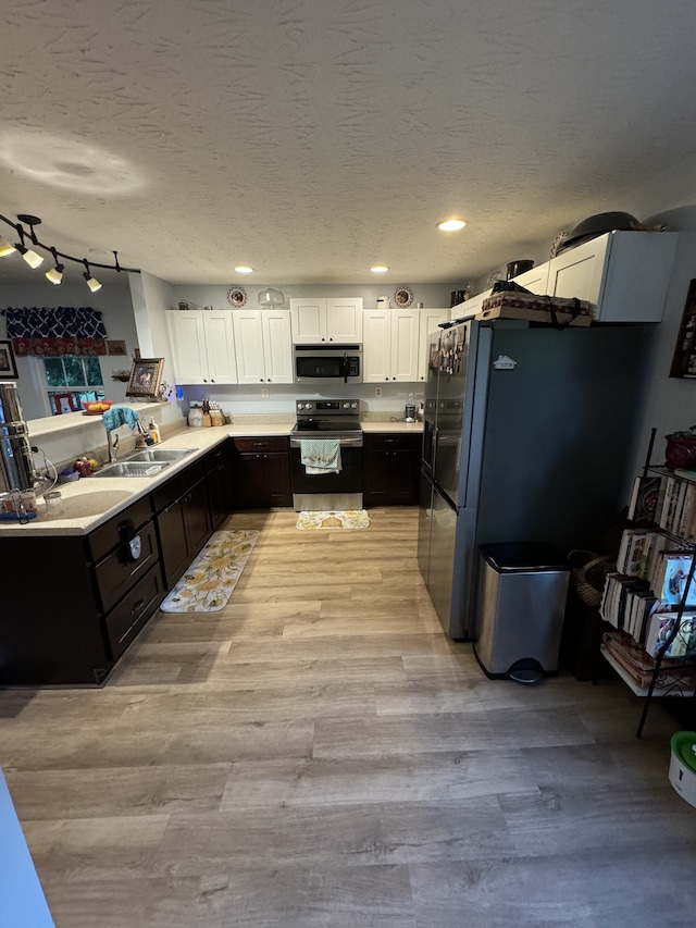 kitchen featuring light hardwood / wood-style flooring, stainless steel appliances, white cabinets, and track lighting