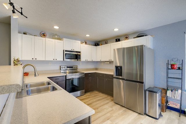 kitchen featuring light hardwood / wood-style flooring, sink, appliances with stainless steel finishes, and white cabinetry