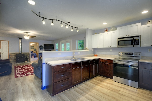 kitchen featuring appliances with stainless steel finishes, light hardwood / wood-style floors, sink, track lighting, and ceiling fan