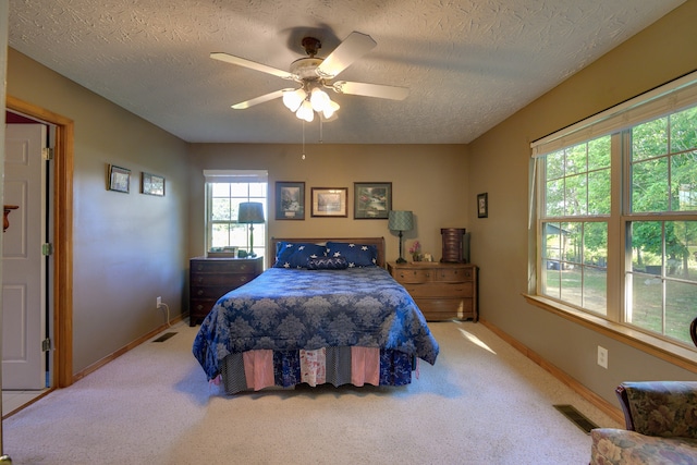 carpeted bedroom with a textured ceiling and ceiling fan