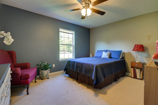 carpeted bedroom featuring a textured ceiling and ceiling fan