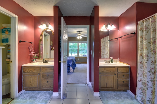 bathroom with tile patterned flooring, vanity, toilet, and ceiling fan