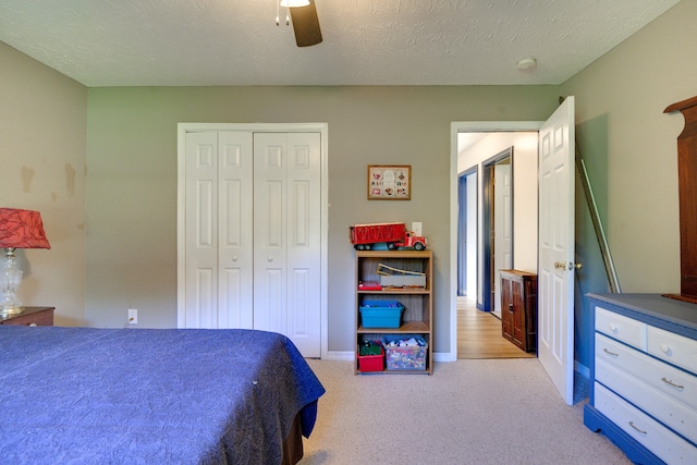 carpeted bedroom featuring a textured ceiling, ceiling fan, and a closet