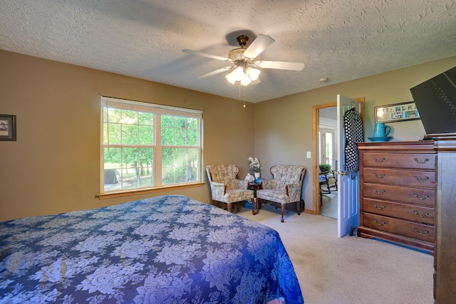 bedroom with a textured ceiling, ceiling fan, and carpet