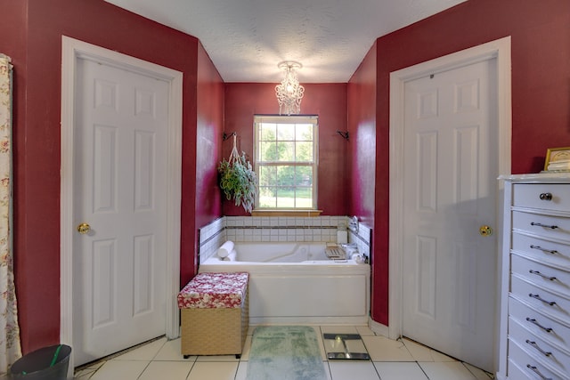 bathroom with a textured ceiling, tile patterned floors, and a bathtub