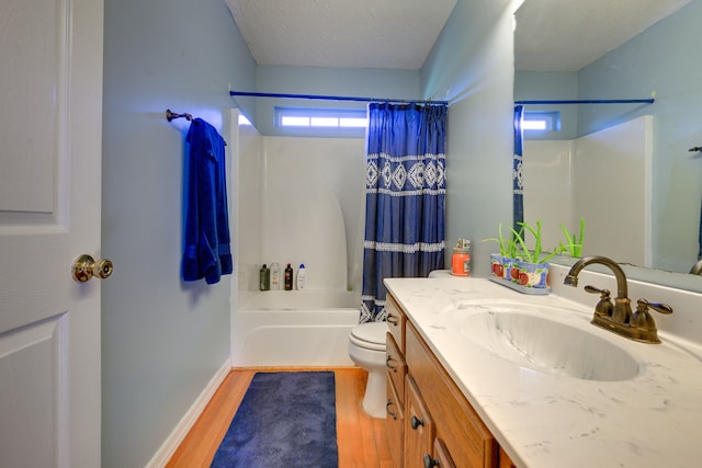 full bathroom featuring a textured ceiling, vanity, hardwood / wood-style floors, toilet, and shower / bath combo with shower curtain