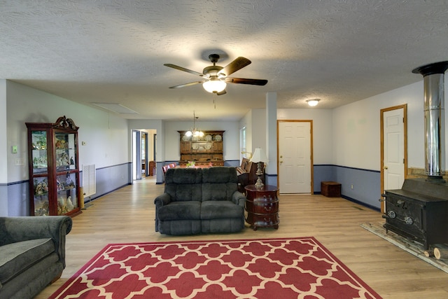 living room featuring a textured ceiling, light hardwood / wood-style flooring, and ceiling fan