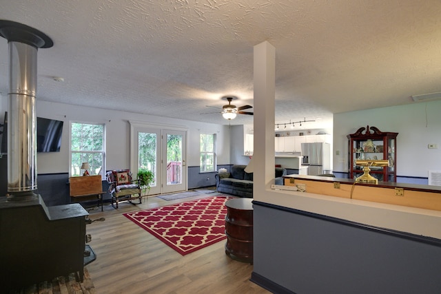 living room featuring a textured ceiling, french doors, ceiling fan, and hardwood / wood-style flooring