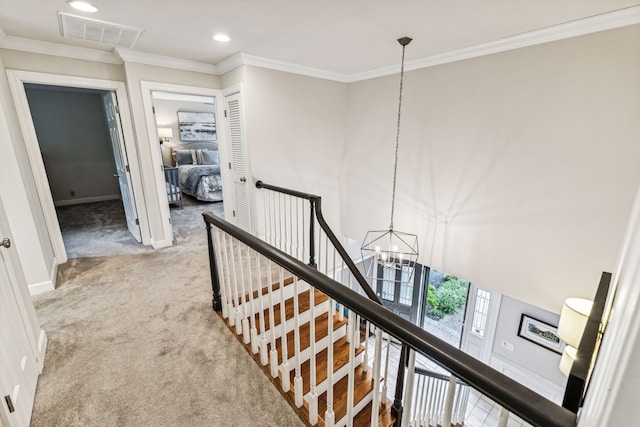 corridor featuring crown molding, an inviting chandelier, and light colored carpet