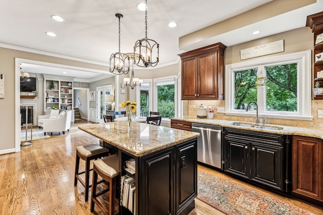 kitchen with light hardwood / wood-style flooring, dishwasher, a center island, an inviting chandelier, and sink