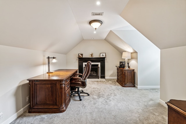 office space with lofted ceiling and light carpet