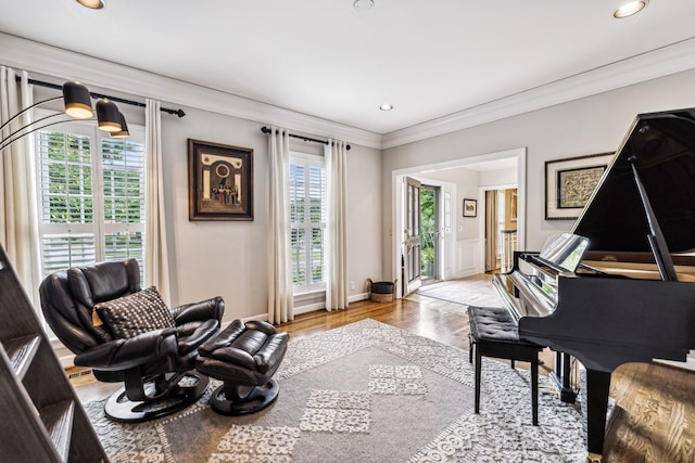 living area featuring a wealth of natural light, crown molding, and light hardwood / wood-style floors