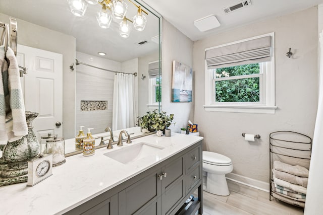 bathroom with vanity, toilet, walk in shower, and an inviting chandelier