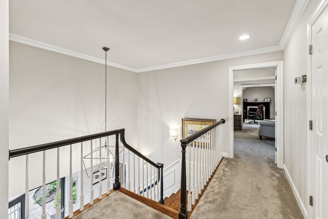 hall featuring ornamental molding, an inviting chandelier, and carpet floors