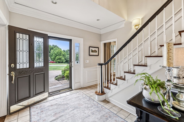 tiled entryway featuring crown molding