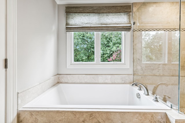 bathroom with a relaxing tiled tub