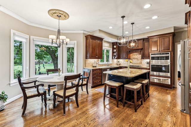 kitchen featuring dark wood-type flooring, hanging light fixtures, a center island, and a chandelier