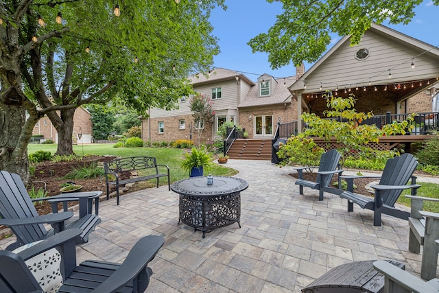 view of patio with an outdoor fire pit and a deck