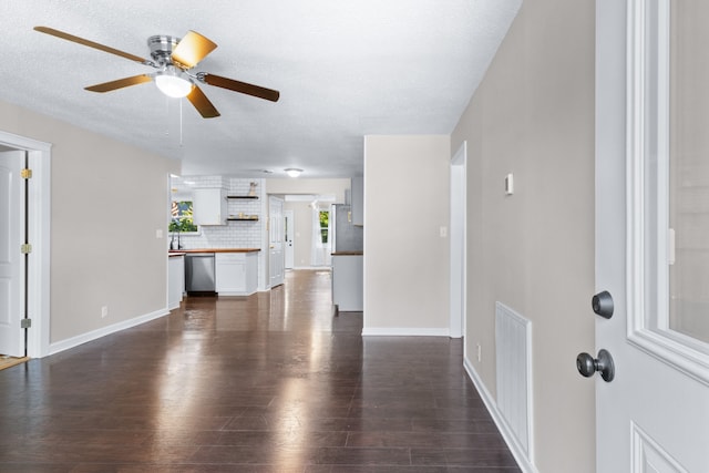 unfurnished living room with a textured ceiling, ceiling fan, and wood-type flooring