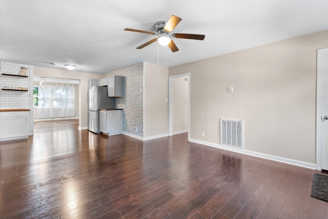 unfurnished living room with ceiling fan, hardwood / wood-style flooring, and a textured ceiling